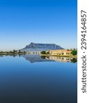 Vertical shot of the table mountain and its reflection in the woodbridge island lagoon during a clear day with blue sky, Cape Town South Africa