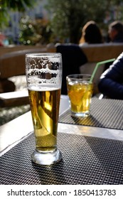 A Vertical Shot Of A Tall Glass Of Beer On A Rubber Mat