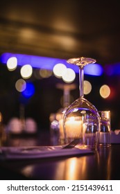 A Vertical Shot Of An Upside Down Wine Glass On A Bokeh Background