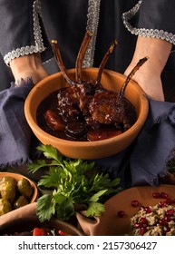 A Vertical Shot Of A Waitress Presenting A Tomahawk Steak