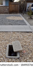 A Vertical Shot Of A Water Manhole On A Gravel Yard