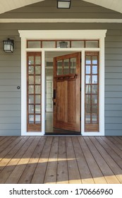 Vertical Shot Of Wooden Front Door  Of An Upscale Home With Windows/Exterior Shot Of An Open Wooden Front Door