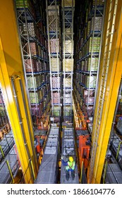 Vertical shot of a worker standing below foodstuffs merchandise that is stored in warehouse with an automated storage and retrieval system - Shutterstock ID 1866104776