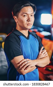Vertical Shot Of Young Asian Guy, Male Cyber Sport Gamer Keeping Arms Crossed And Looking At Camera While Participating In ESports Tournament Or Competition