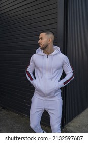 A Vertical Shot Of A Young Cool Hip Male In A White Sweatsuit Posing