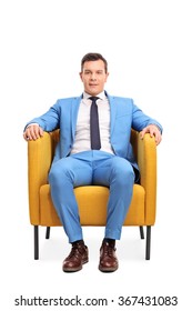 Vertical Shot Of A Young Man In An Elegant Blue Suit Sitting In An Armchair Isolated On White Background