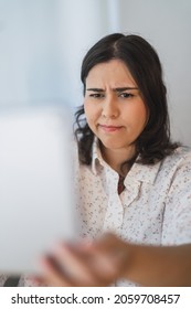 A Vertical Shot Of A Young Spanish Girl Using A Tablet Indoors