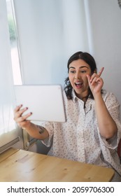 A Vertical Shot Of A Young Spanish Woman Using A Tablet Indoors