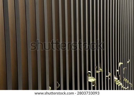Vertical slats create a textured background with scattered golden leaves.