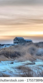 Vertical Solitary Home On Snowy Hill With Flowering Wild Grasses In The Foreground