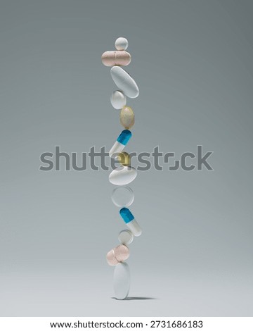 Vertical stack of balanced tablets and capsules on gray background with copy space for pharmacy, wellness, dosage or safety message.