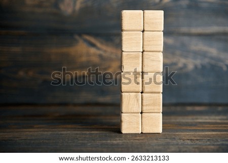 Vertical stack of blank wooden cubes on wooden surface with copy space