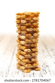 Vertical stack of rawhide dog chew treats on a rustic wooden background.