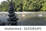 A vertical stack of river stones, carefully balanced and symmetrically arranged, set against a flowing stream backdrop—symbolizing harmony, inner peace, and the delicate balance of nature.
