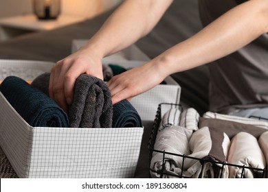 Vertical storage of clothing.Women organize clothes in a modern bedroom. Women sorting clothes in baskets room cleaning concept.