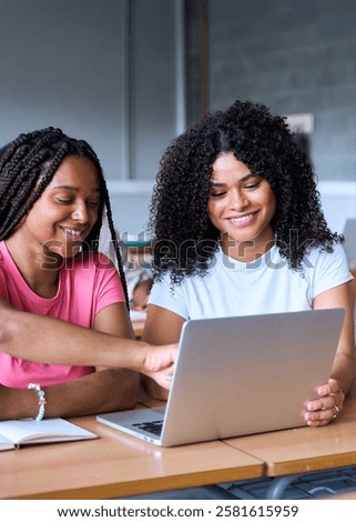 Vertical. Students are studying with computer laptop in classroom. Young people are spending time together. Young cheerful African American girl are working together. High quality photo
