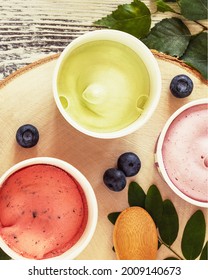 Vertical, Summer, Food Composition With Natural, Vegan Ice Cream, Blueberries, Leaves And Wooden Spoon On White Wooden Background. Eco Friendly Still Life With Berry, Frozen Yogurt. Flat Lay