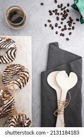 A Vertical Top View Of Chocolate Cream Donuts On A Messy Kitchen Table