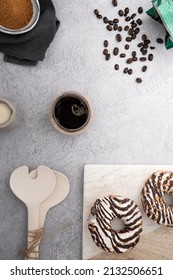 A Vertical Top View Of Chocolate Cream Donuts On A Messy Kitchen Table