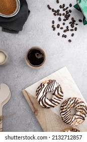 A Vertical Top View Of Chocolate Cream Donuts On A Messy Kitchen Table