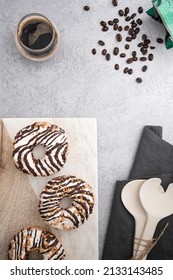 A Vertical Top View Of Chocolate Cream Donuts On A Messy Kitchen Table