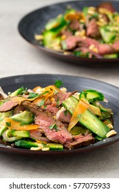 Vertical View Of 2 Plates Of Asian Beef Salad. Inspired By Thai And Vietnamese Salads, Packed With Fresh Healthy Vegetables (carrots, Onions, Cucumber, Etc) And A Nicely Seared Flank Steak.