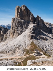 Vertical view of Averau peak cliffs and mountain hut, Dolomites hiking destination, Italy
