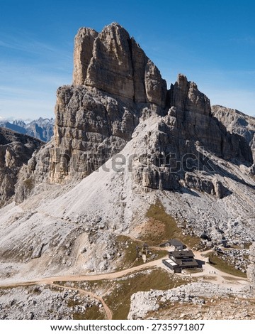 Vertical view of Averau peak cliffs and mountain hut, Dolomites hiking destination, Italy