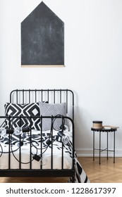 Vertical View Of Blackboard On The Wall Of Teenagers Bedroom With Black And White Patterned Bedding On Single Metal Bed, Real Photo With Mockup