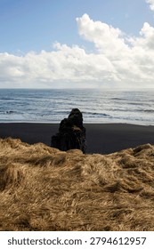Vertical view from a cliff overlooking an isolated basalt rock formation on Reynisfjara black sand beach, Iceland