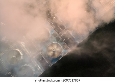 Vertical View Of Cooling Tower Of A Cogeneration Plant. Excess Heat Dissipation Into The Air. Heat And Electricity Production Technology. Steam And Spinning Fans.