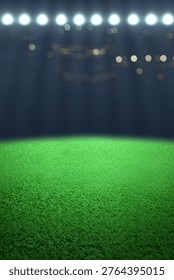 Vertical view of an empty green grass field in a sports stadium at night, illuminated by bright floodlights with a dark bokeh background, ready for a football or soccer match