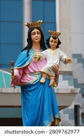 Vertical view of the holy statue of Virgin Mary holding baby Jesus with crowns.
