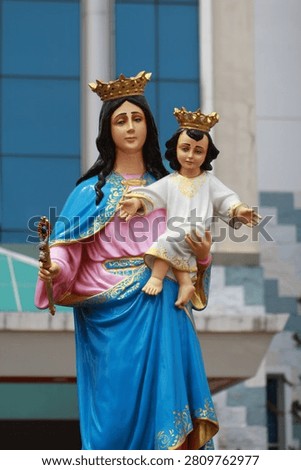 Vertical view of the holy statue of Virgin Mary holding baby Jesus with crowns.