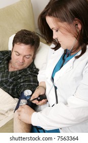 Vertical View Of A Home Health Nurse Taking Patient's Blood Pressure.  Focus On The Nurse