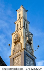 Vertical View of Islamic Mosque Tower with Ornate Architectural Details Against Clear Blue Sky
