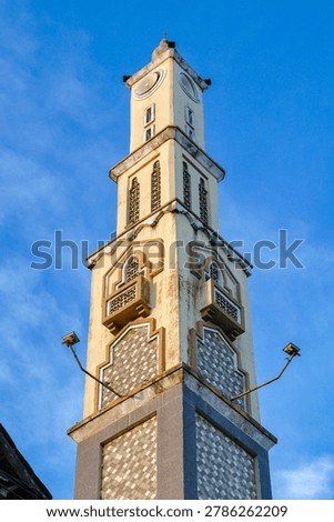 Vertical View of Islamic Mosque Tower with Ornate Architectural Details Against Clear Blue Sky