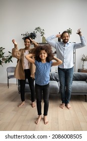 Vertical View Joyful Friendly African American Cute Child Girl Making Funny Moves, Dancing To Popular Music With Happy Supportive Couple Parents, Recording Video For Social Network, Vlogging At Home.