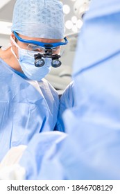 A Vertical View Of A Mid Adult Surgeon Under Selective Focus Wearing Surgical Loupe In The Operating Room