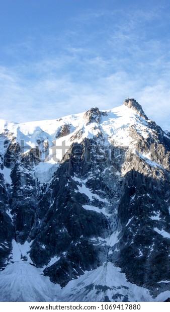vertical view of the north face of the Aiguille du\
Midi with ist many ascent\
routes
