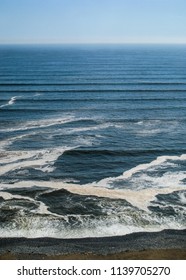 Vertical view of the ocean waves touching the beach sand. Beautiful image of nature and sea. No people.