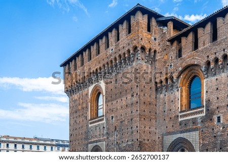 Vertical view of Sforza Castle’s clock tower in Milan, showcasing medieval architecture, red bricks, and historic design. Perfect for travel, tourism, and cultural heritage visuals.