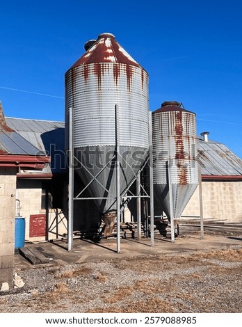 Vertical view of Silo Feed Container On Southern Rural Horse Farm On A Sunny Blue Day During Golden Hour in Tennessee 