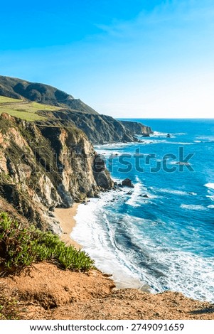 Vertical view of the steep coastal cliffs and hidden beach in Big Sur, California