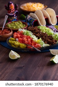 Vertical view of taco shells with a platter of all the fixings ready for eating.
