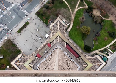 Vertical View From The Top Of The Eiffel Tower In Paris, With Perspective Of The Height Of The Tower And People In The Park Very Far Away Below.