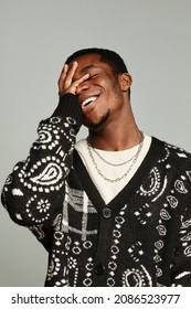 Vertical waist up portrait of anonymous African American man wearing cardigan and laughing