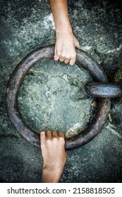 A Vertical Wallpaper Of Two Hands Pulling A Giant Iron Ring Pull From The Ground From Opposite Sides