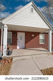 Vertical White Puffy Clouds Exterior Of A Small House With Red Bricks And White Door