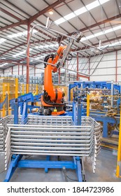 Vertical Wide Shot Of A Robotic Machinery Lifting Steel Gates In A Factory.